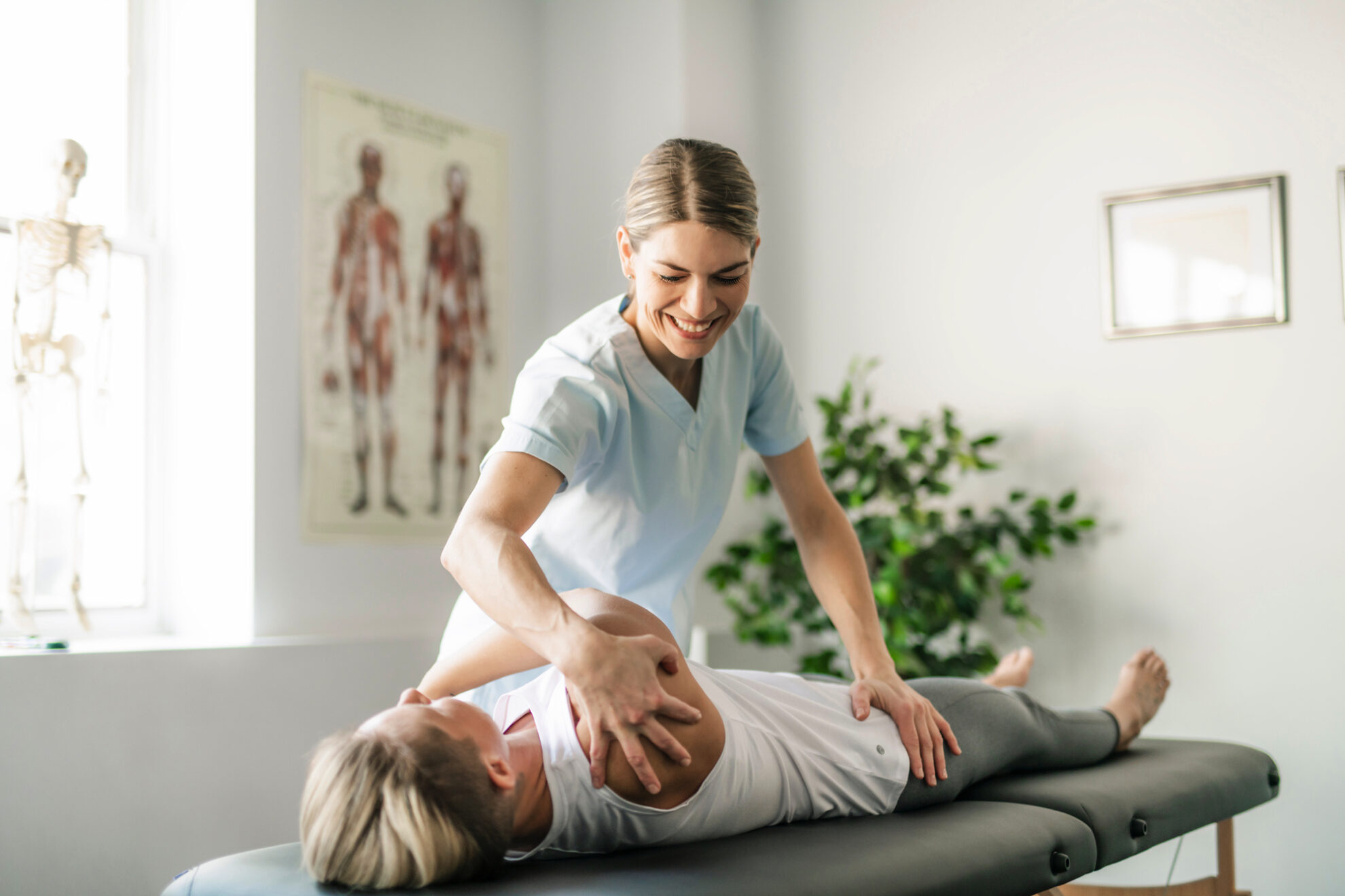 Physiotherapie_Kurdirekt Manuelle Therapie mit Dehnung des Schultergelenk durch eine Therapeutin bei der Physiotherapie